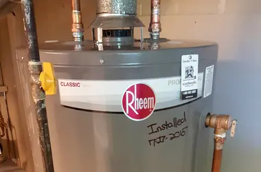 Gas water heater against a brick basement wall